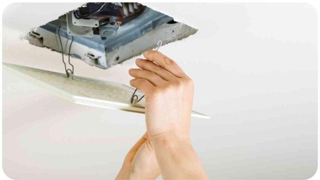 a person fixing a ceiling fan with a piece of paper