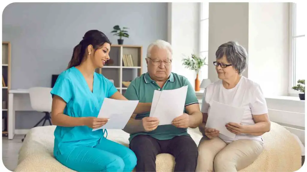 an elderly couple sitting on a bed with two nurses looking at a piece of paper