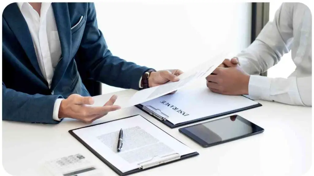 two people sitting at a table with paperwork