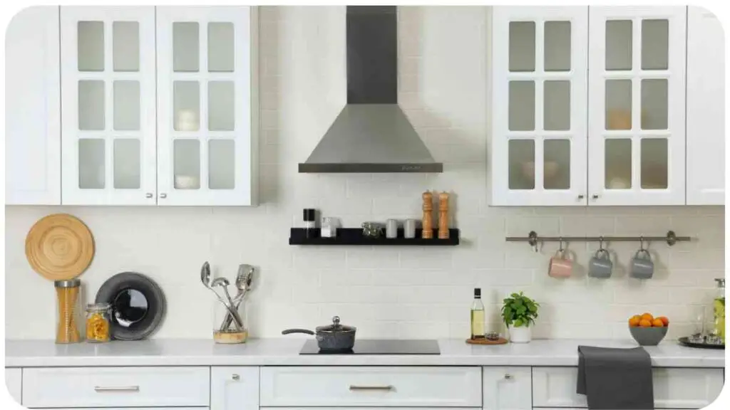 a kitchen with white cabinets and a stove hood