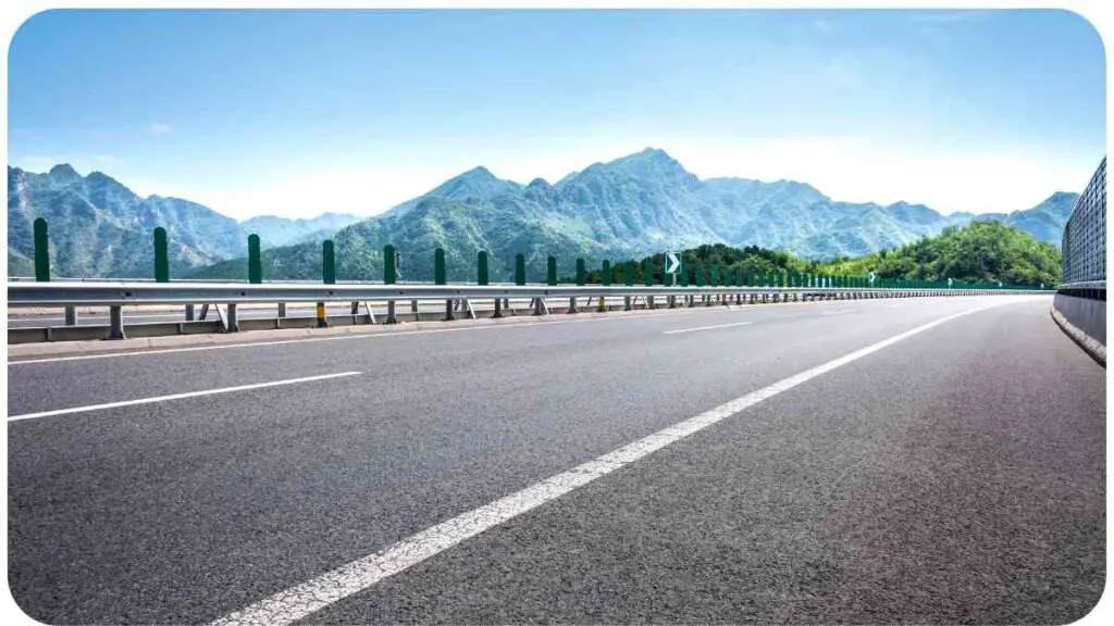 an empty highway with mountains in the background