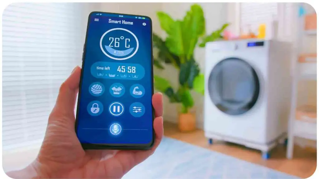 a hand holding a smart phone in front of a washing machine