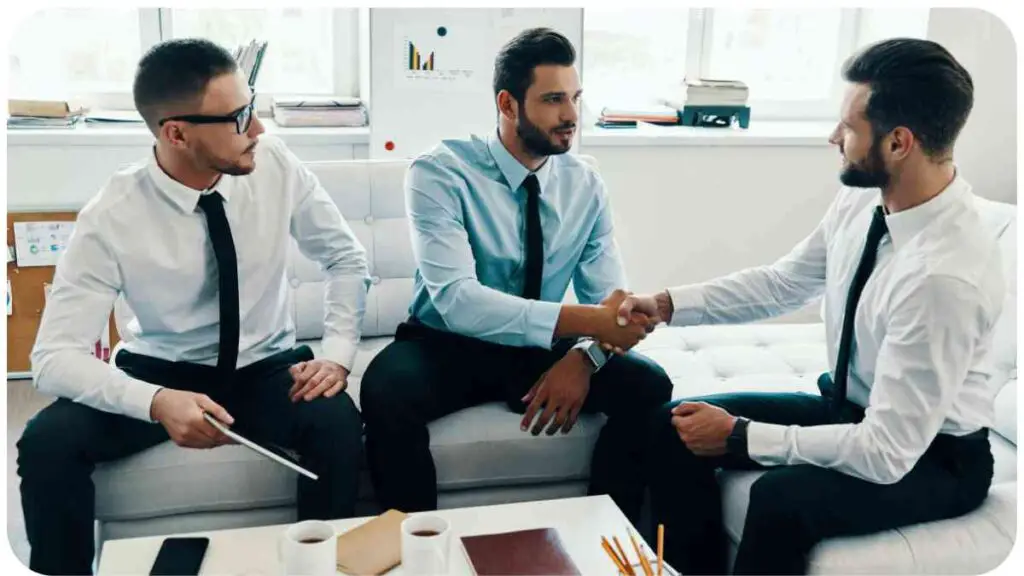 three individuals shaking hands in an office